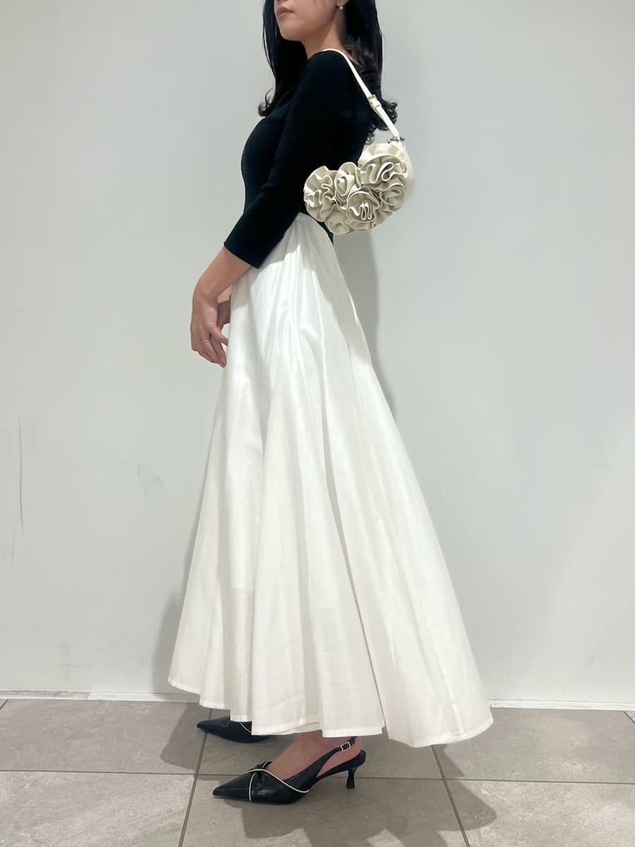 ブラック系のパンプス、ホワイト系のハンドバッグ、その他のワンピースを着用したレディースの冬コーディネートの2枚目の写真