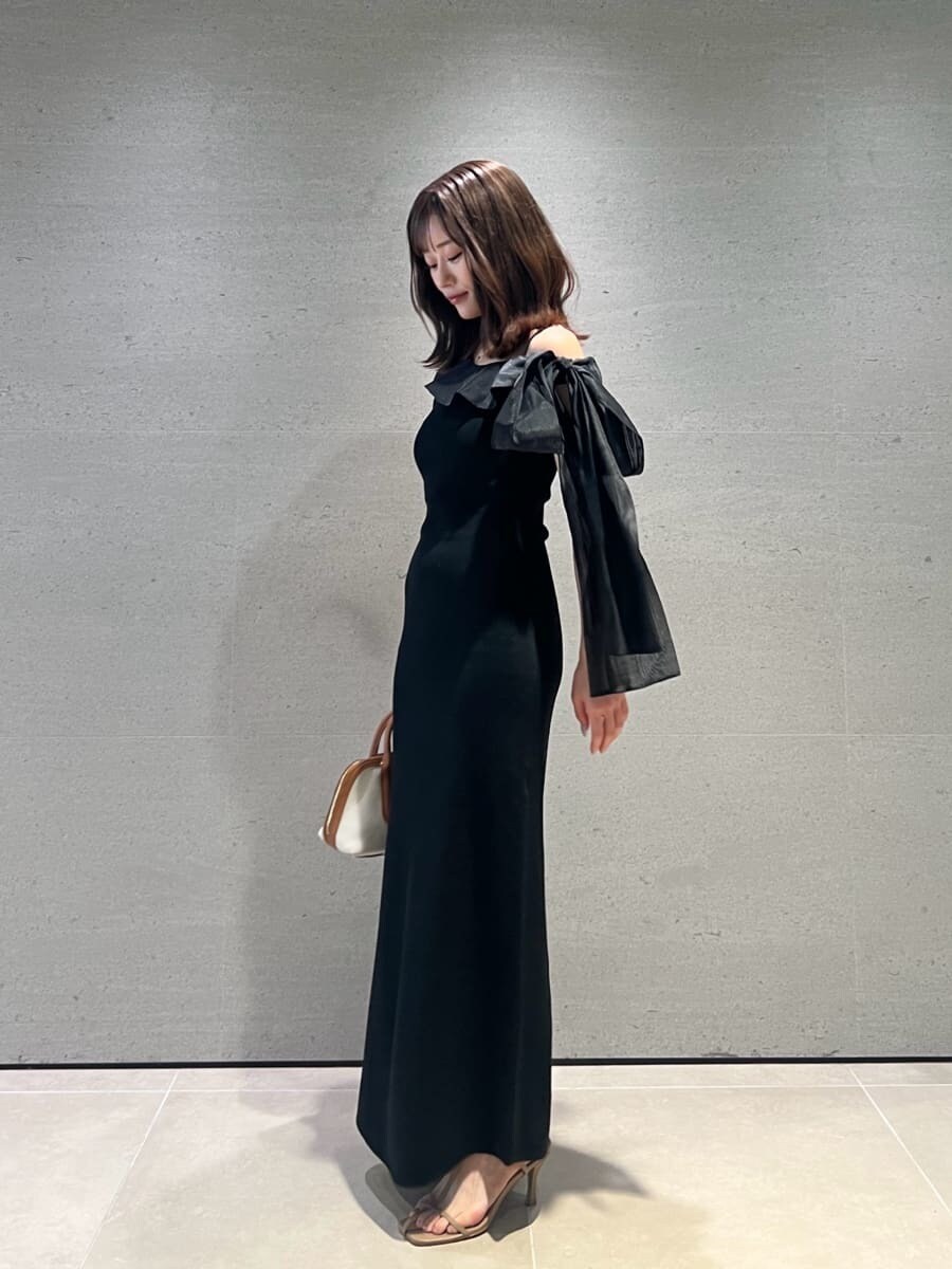 ブラック系のワンピース、イエロー系のボストンバッグ、ベージュ系のサンダルを着用したレディースの夏コーディネートの4枚目の写真