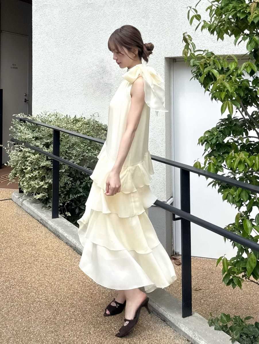 イエロー系のドレス、ブラウン系のサンダル、レッド系のショルダーバッグを着用したレディースの夏コーディネートの2枚目の写真