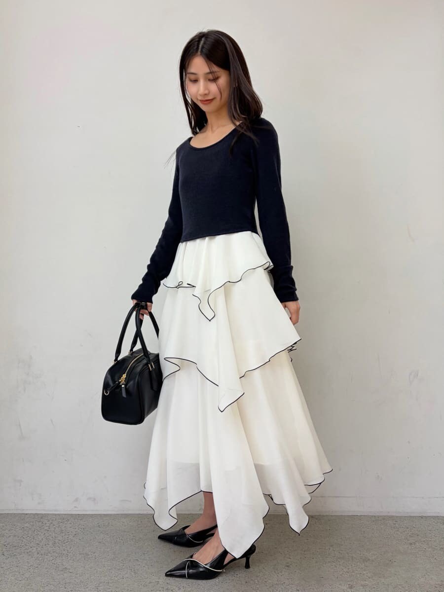 ベージュ系のトレンチコート、ブルー系のワンピース、ブラック系のパンプスを着用したレディースの冬コーディネートの6枚目の写真