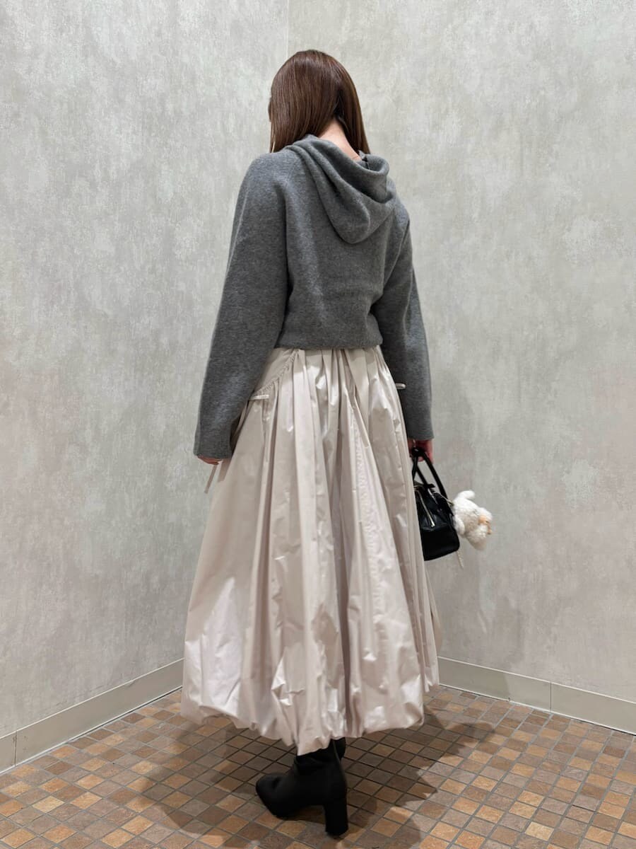 ベージュ系のスカート、ブラック系のボストンバッグ、ホワイト系のキーケース/キーアクセサリーを着用したレディースの秋コーディネートの4枚目の写真