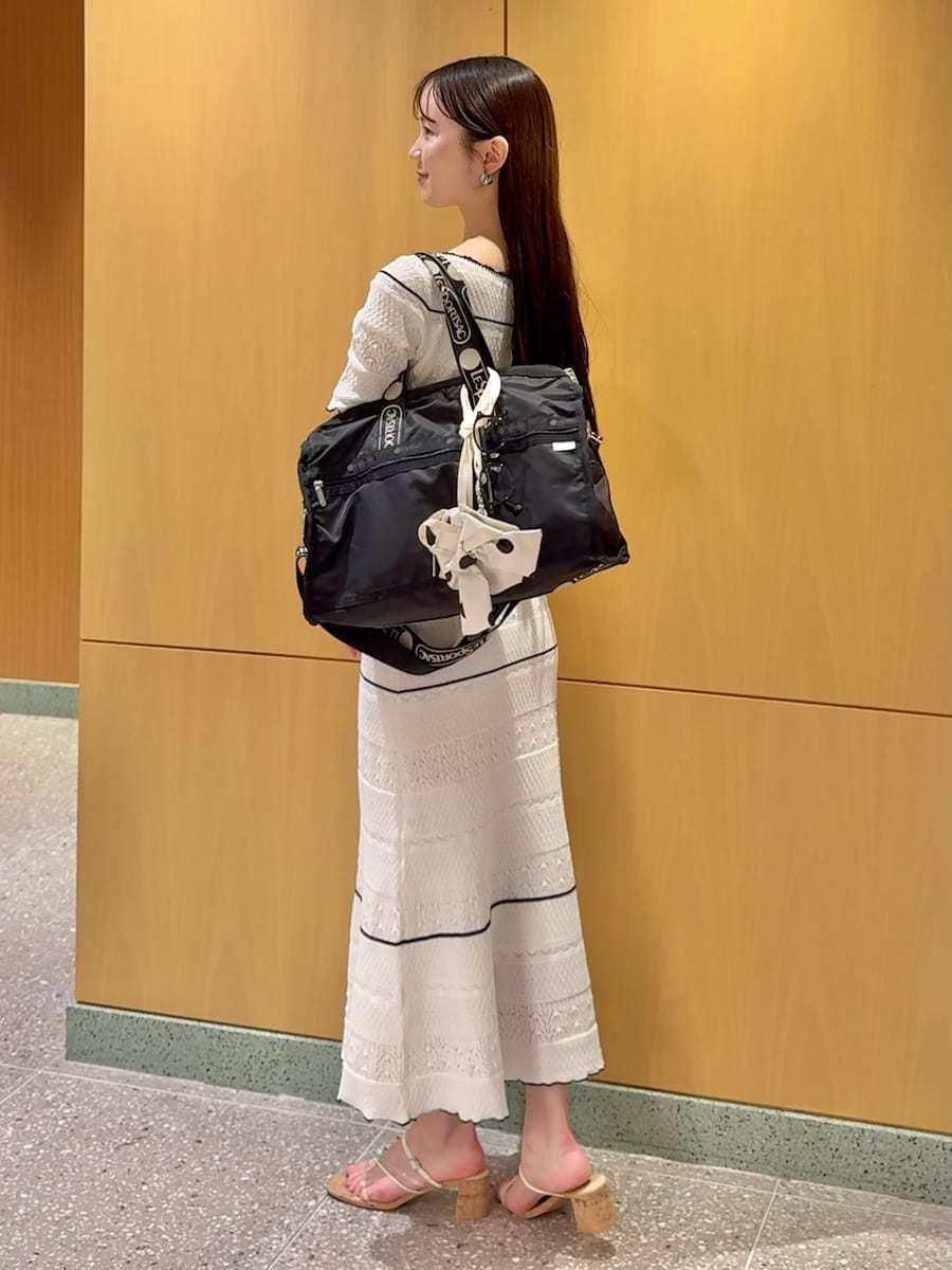 ホワイト系のワンピース、ブラック系のショルダーバッグ、その他のサンダルを着用したレディースの春コーディネートの3枚目の写真