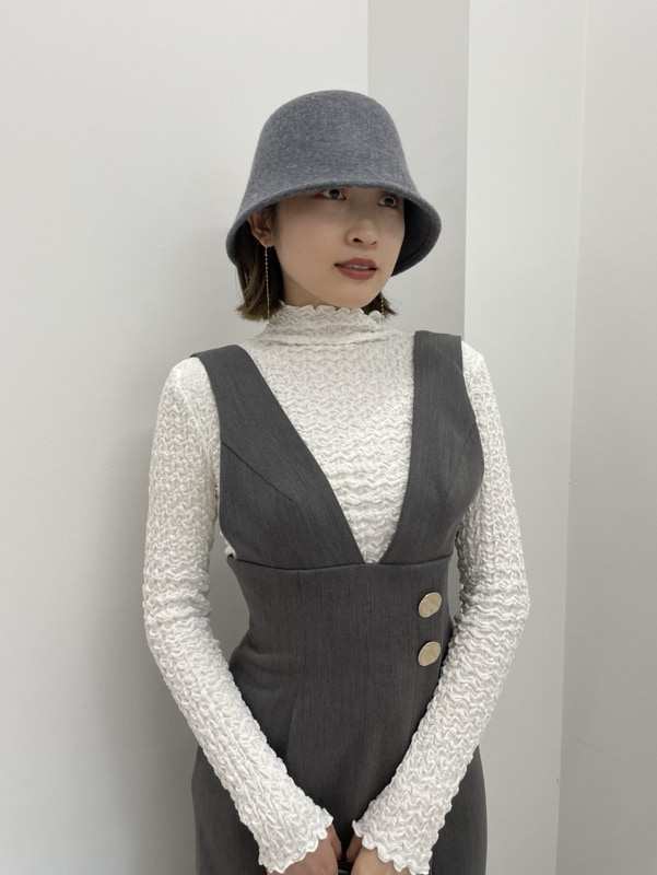 グレー系のワンピース、ブラック系のショルダーバッグ、ブラック系のブーツを着用したレディースの秋コーディネートの3枚目の写真