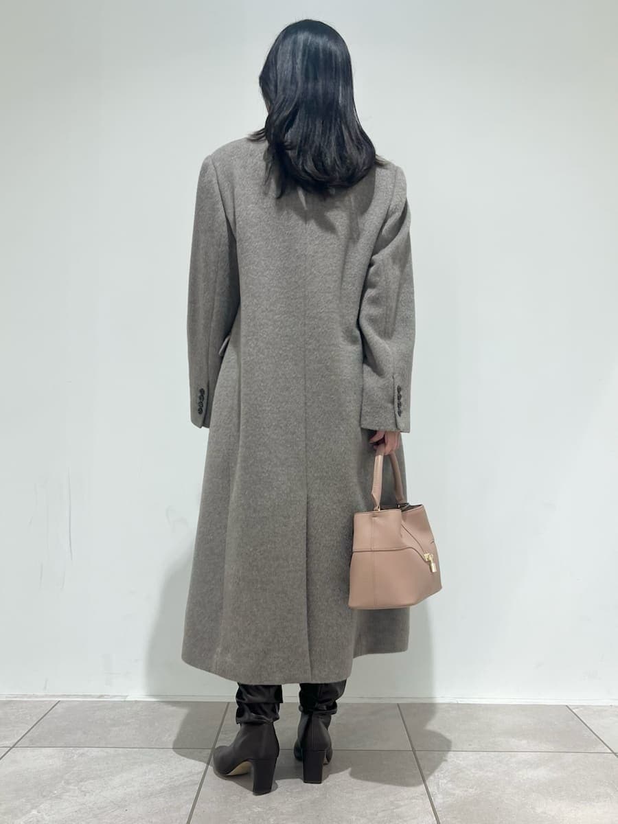 ピンク系のショルダーバッグ、ベージュ系のチェスターコート、ホワイト系のその他パンツを着用したレディースの冬コーディネートの3枚目の写真