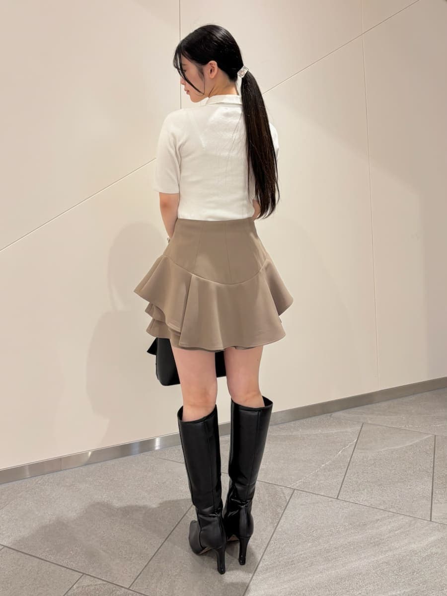 ブラック系のブーツ、ホワイト系のニット/セーター、ブラック系のハンドバッグを着用したレディースの冬コーディネートの4枚目の写真