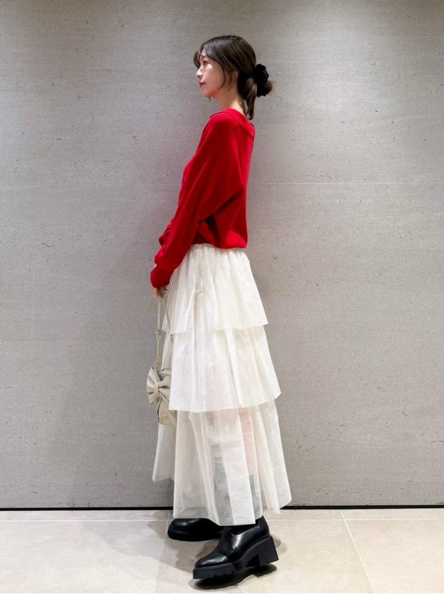 ホワイト系のスカート、レッド系のニット/セーター、ホワイト系のショルダーバッグを着用したレディースの秋コーディネートの3枚目の写真