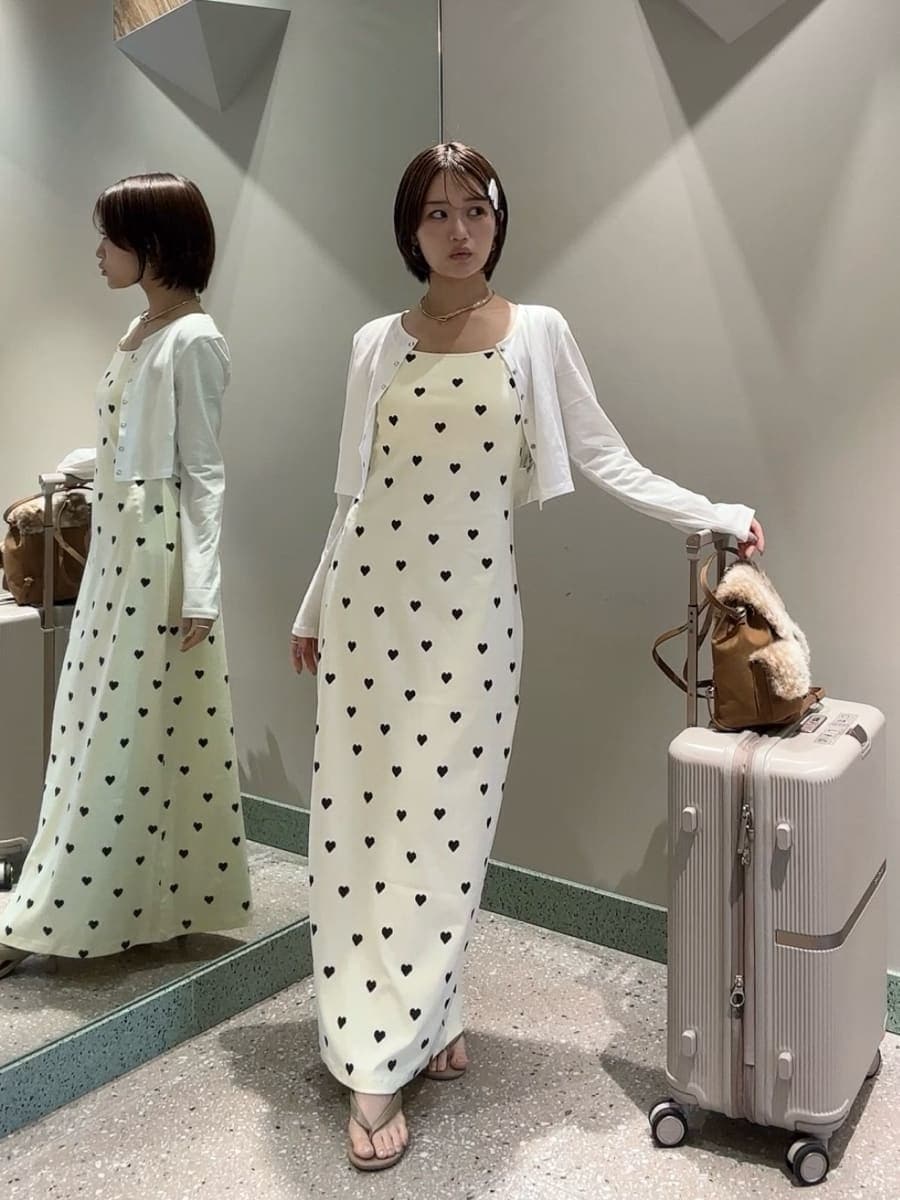 イエロー系のワンピース、ホワイト系のカーディガン/ボレロ、その他のバックパック/リュックを着用したレディースの夏コーディネートの2枚目の写真