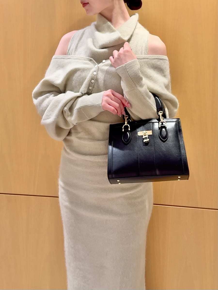 ブラック系のブーツ、グリーン系のワンピース、ブラック系のハンドバッグを着用したレディースの冬コーディネートの7枚目の写真