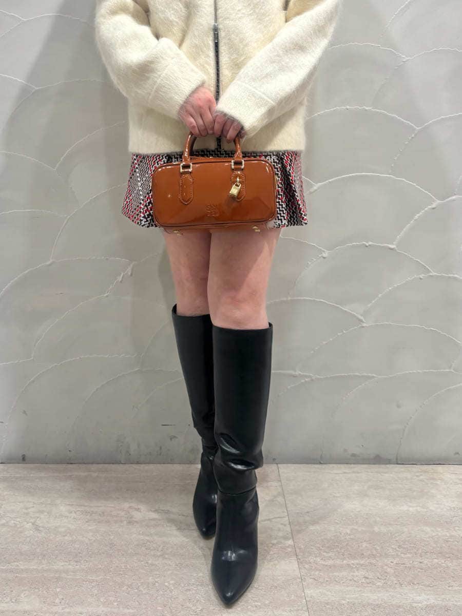 ホワイト系のブルゾン、レッド系のスカート、ブラック系のブーツを着用したレディースの冬コーディネートの4枚目の写真