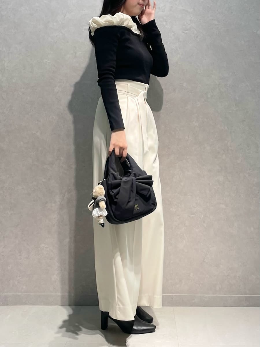 ブラック系のブーツ、ホワイト系のその他パンツ、ブラック系のニット/セーターを着用したレディースの冬コーディネートの2枚目の写真