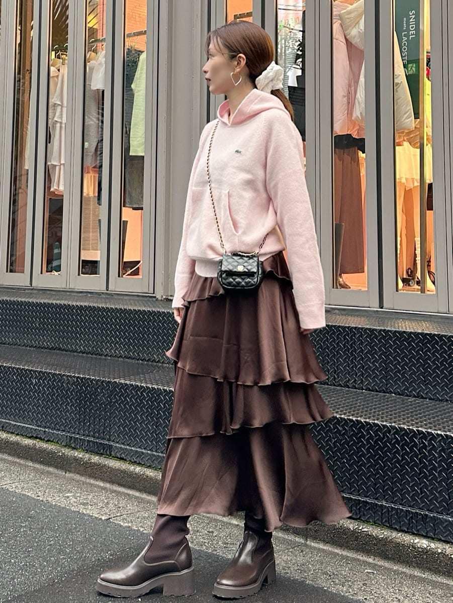 ピンク系のニット/セーター、ブラウン系のスカート、ブラック系のショルダーバッグを着用したレディースの秋コーディネートの3枚目の写真