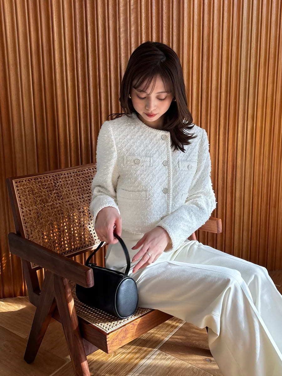 ホワイト系のスラックス、ホワイト系のノーカラージャケットを着用したレディースの冬コーディネートの3枚目の写真