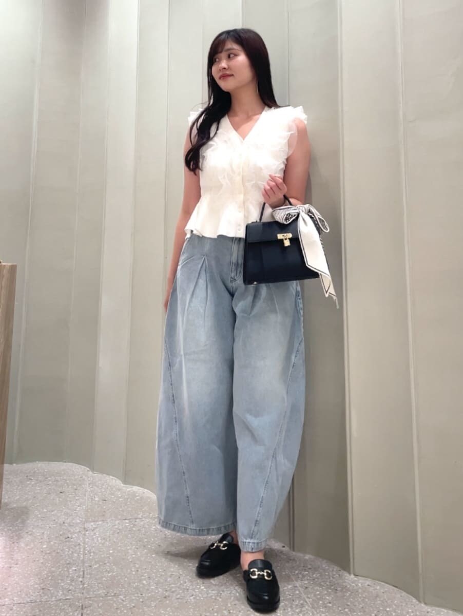 ブラック系のハンドバッグ、ブルー系のデニムパンツ、ホワイト系のニット/セーターを着用したレディースの夏コーディネートの3枚目の写真