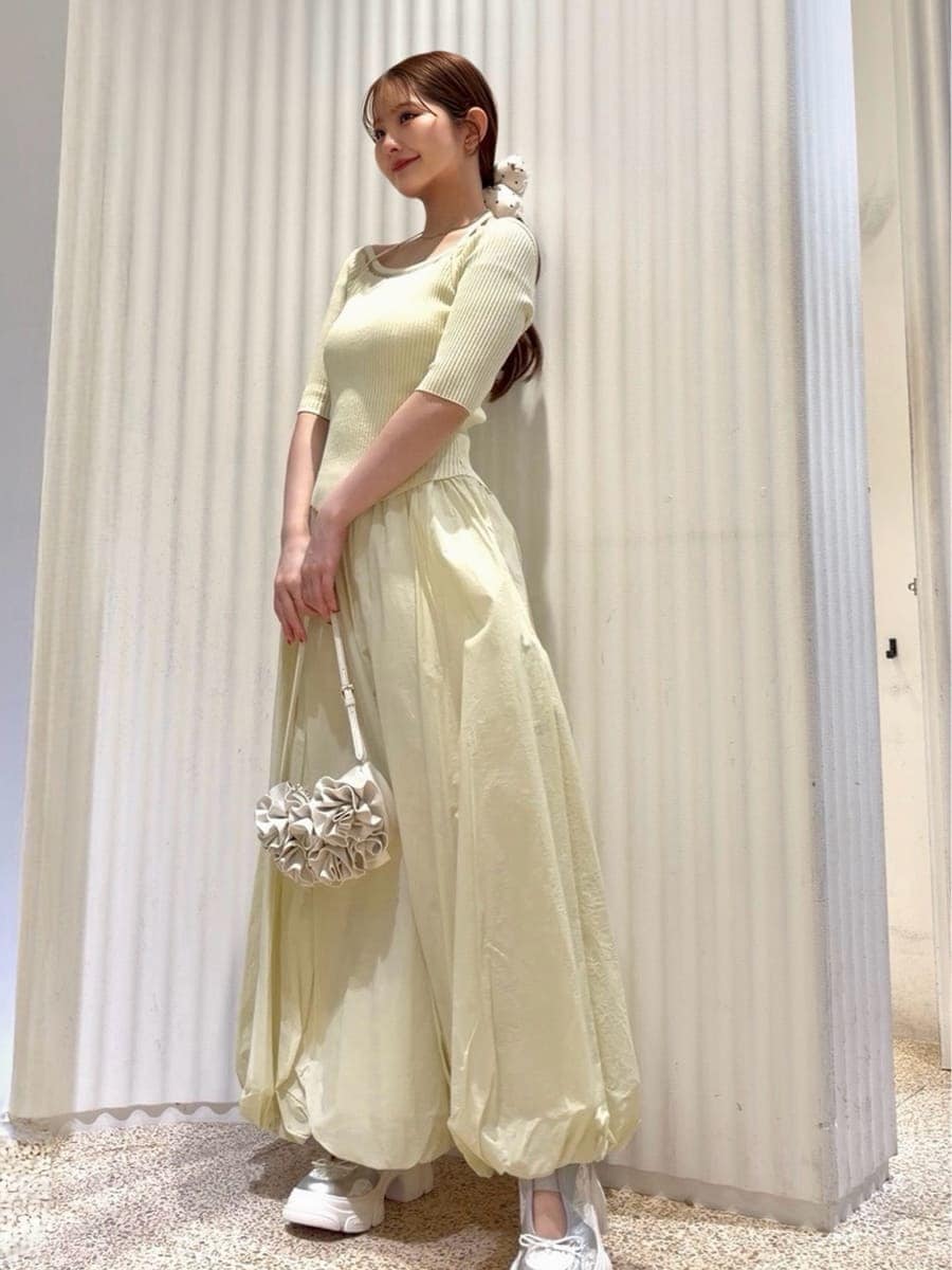 ホワイト系のハンドバッグ、ホワイト系のパンプス、ゴールド系のイヤリングを着用したレディースの春コーディネートの2枚目の写真