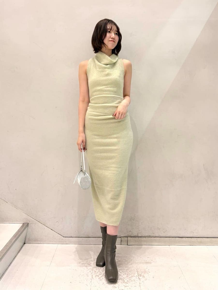 ベージュ系のキャミソール、グリーン系のチェスターコート、グリーン系のワンピースを着用したレディースの冬コーディネートの2枚目の写真