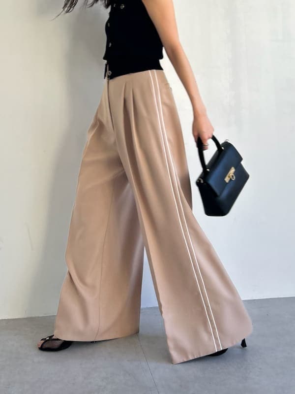 ブラック系のニット/セーター、ベージュ系のその他パンツ、ブラック系のショルダーバッグを着用したレディースの春コーディネートの9枚目の写真