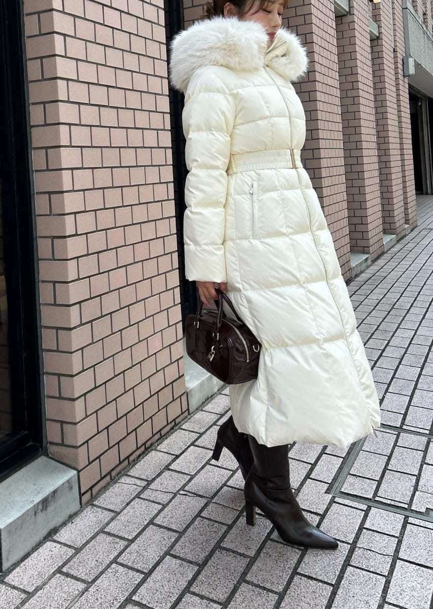 ブラック系のブーツ、ブラック系のボストンバッグ、ホワイト系のダウンジャケット/コートを着用したレディースの秋コーディネートの7枚目の写真