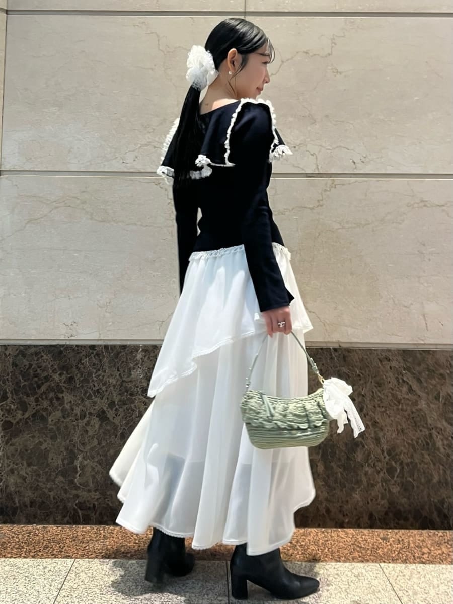 ホワイト系のスカート、ブルー系のニット/セーター、その他のピアス（両耳用）を着用したレディースの冬コーディネートの3枚目の写真