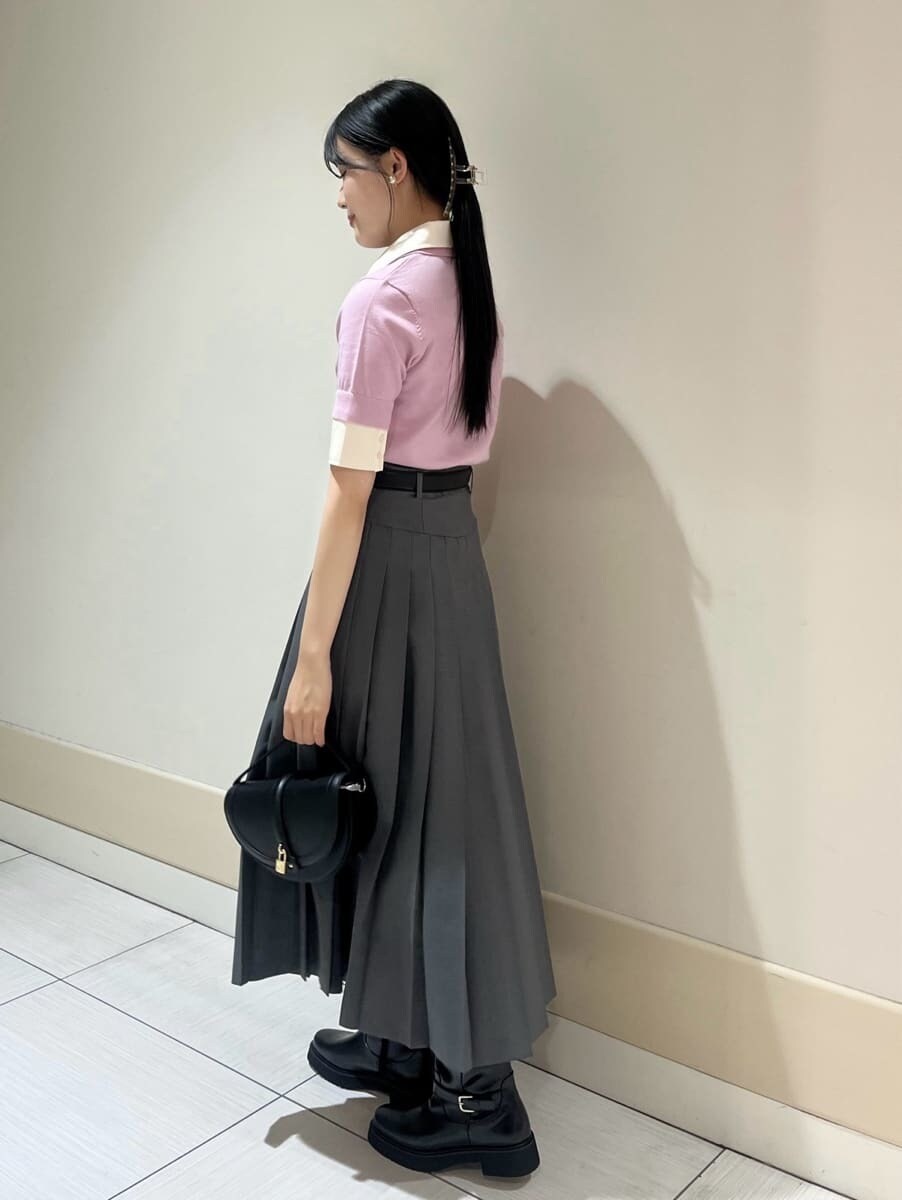 ピンク系のニット/セーター、グレー系のスカート、ブラック系のハンドバッグを着用したレディースの夏コーディネートの2枚目の写真