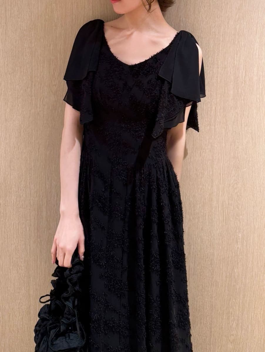 ブラック系のワンピース、ブラック系のパンプスを着用したレディースの春コーディネートの3枚目の写真