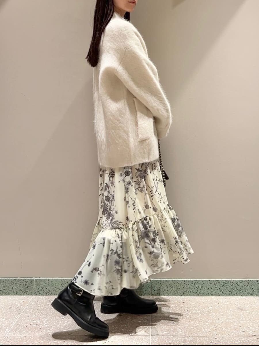 ホワイト系のブルゾン、イエロー系のワンピース、ブラック系のブーツを着用したレディースの秋コーディネートの3枚目の写真