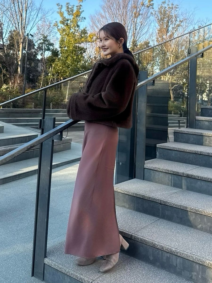 ブラウン系のステンカラーコートを着用したレディースの冬コーディネートの2枚目の写真