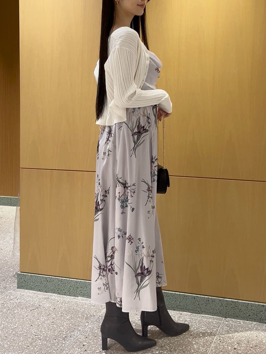 グレー系のブーツ、ホワイト系のカーディガン/ボレロ、パープル系のワンピースを着用したレディースの冬コーディネートの4枚目の写真