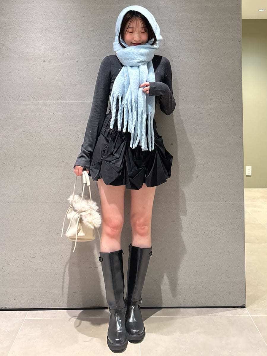 ブラック系のブーツ、ブルー系のチェスターコート、ブラック系のその他パンツを着用したレディースの冬コーディネートの3枚目の写真