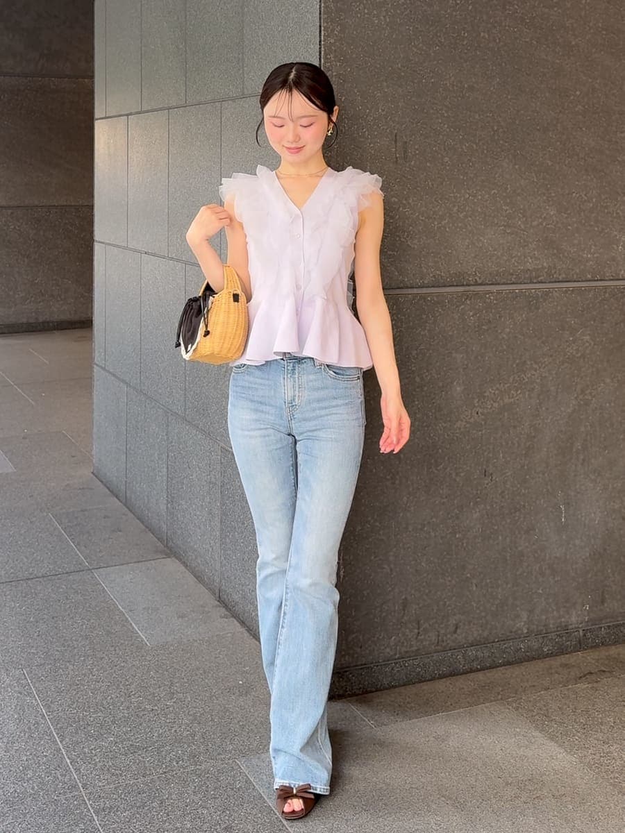 ブルー系のデニムパンツ、ブラック系のかごバッグ、パープル系のニット/セーターを着用したレディースの夏コーディネートの2枚目の写真