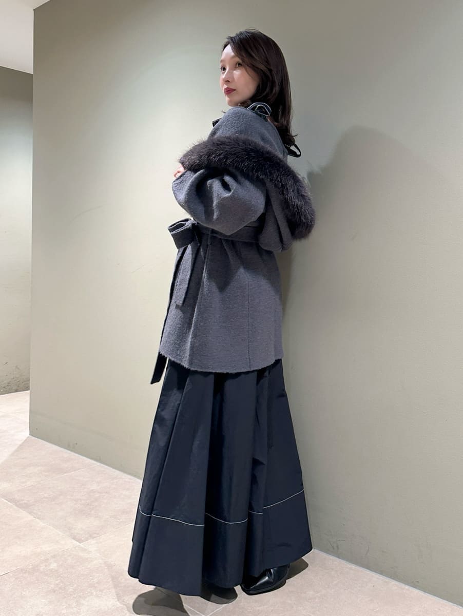 ブラック系のワンピース、ブラウン系のハンドバッグ、ブラック系のブーツを着用したレディースの秋コーディネートの2枚目の写真