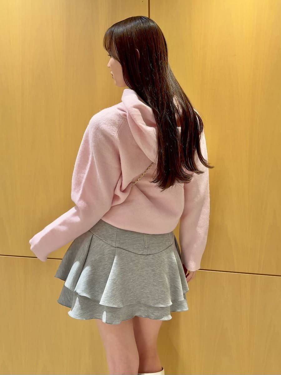 ホワイト系のショルダーバッグ、ピンク系のニット/セーター、ホワイト系のブーツを着用したレディースの冬コーディネートの3枚目の写真