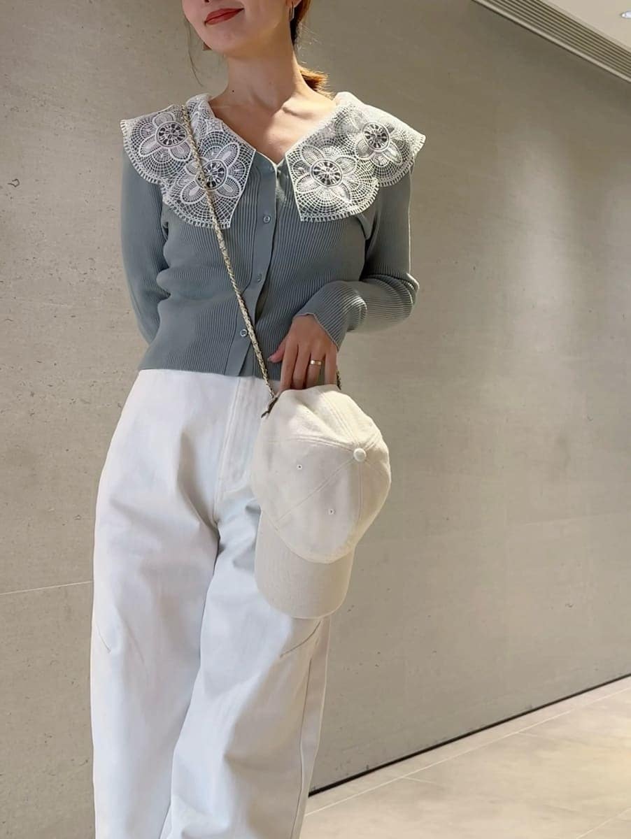 ホワイト系のショルダーバッグ、グリーン系のニット/セーター、ホワイト系のキャップを着用したレディースの冬コーディネートの2枚目の写真