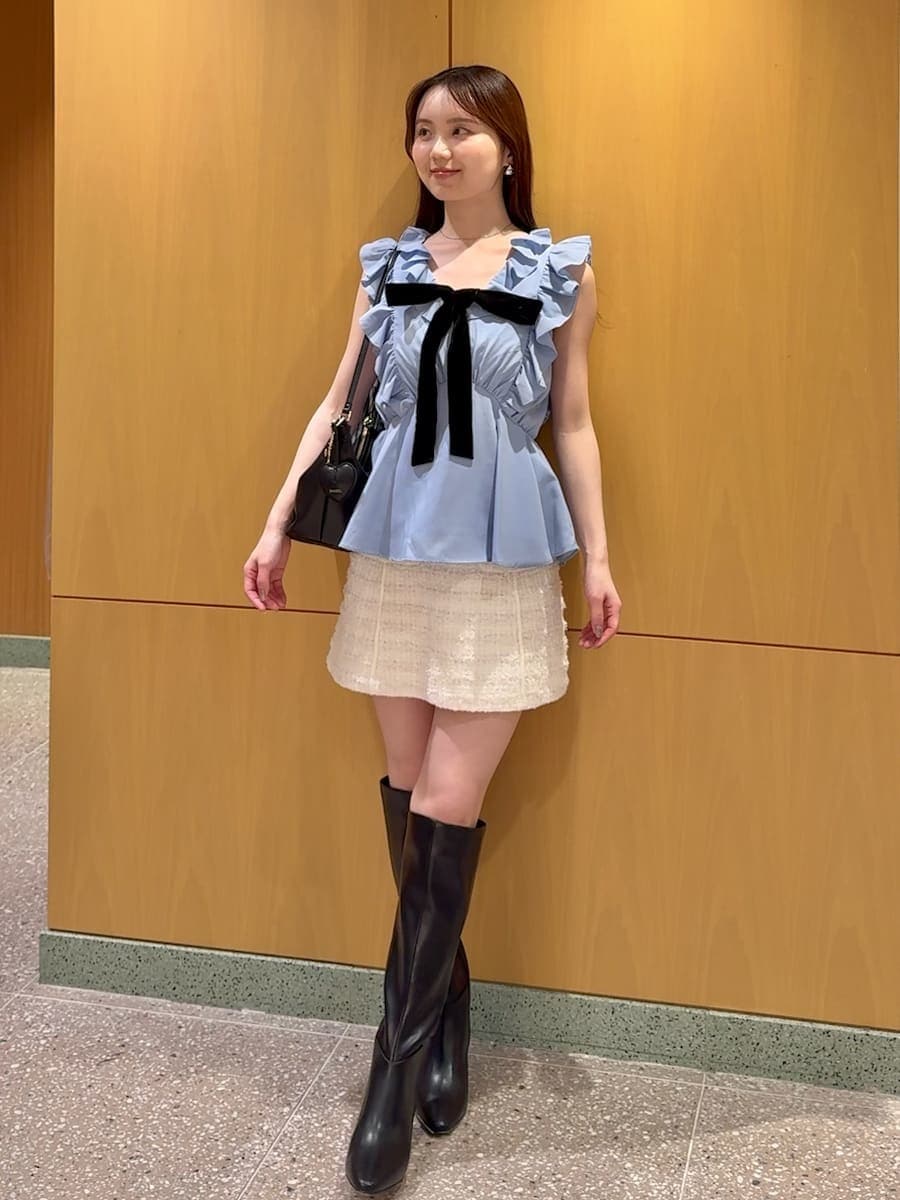 ホワイト系のスカート、ブルー系のシャツ/ブラウス、ブラック系のブーツを着用したレディースの夏コーディネートの2枚目の写真