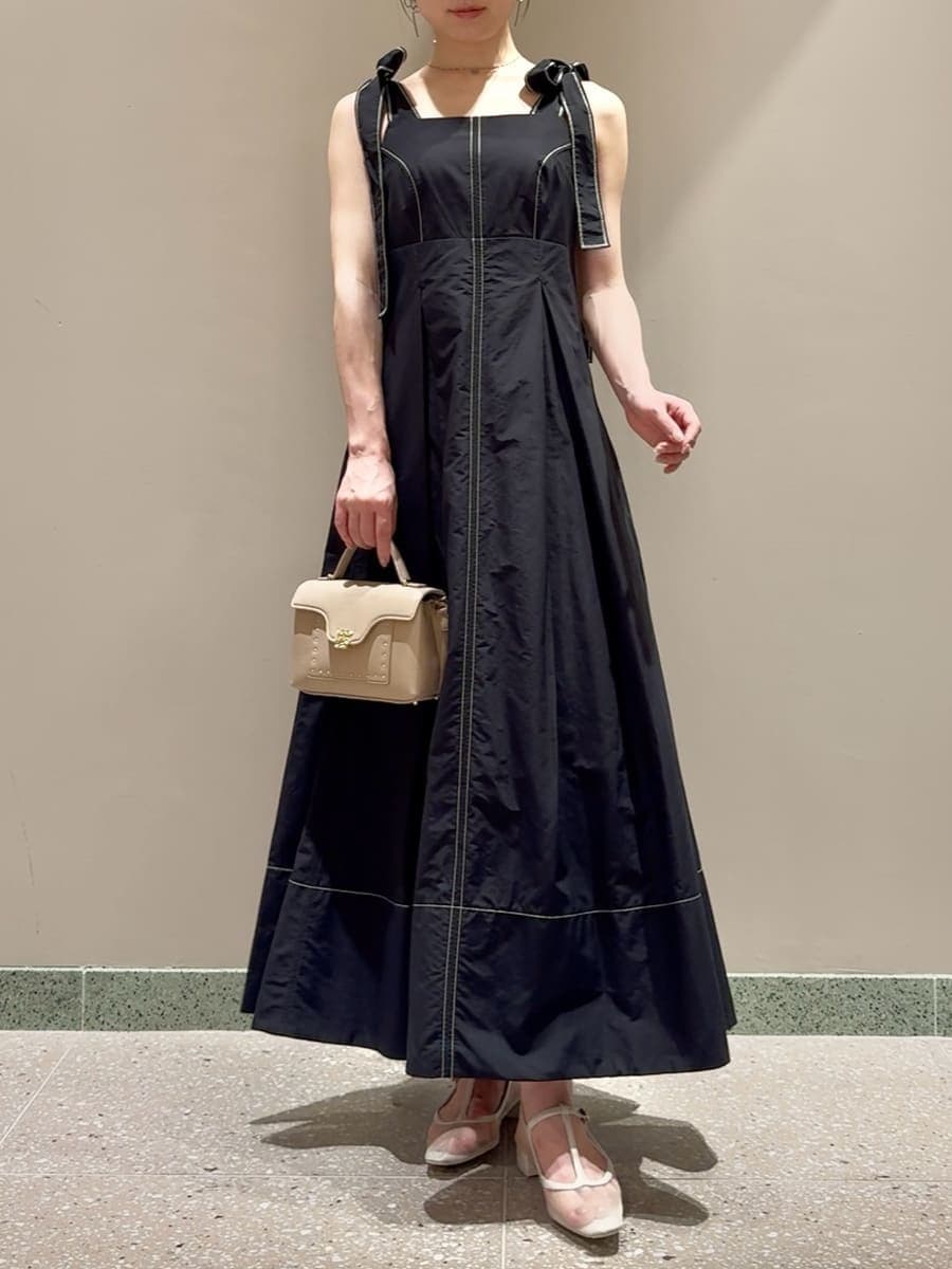 ブラック系のワンピース、ベージュ系のショルダーバッグ、シルバー系のネックレスを着用したレディースの夏コーディネートの7枚目の写真