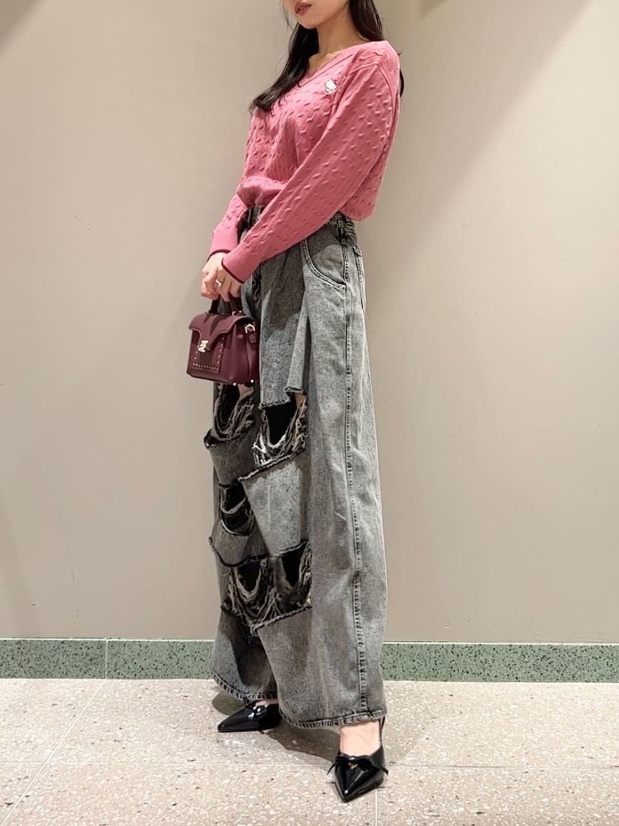 ピンク系のニット/セーター、グレー系のデニムパンツ、ブラウン系のショルダーバッグを着用したレディースの秋コーディネートの3枚目の写真