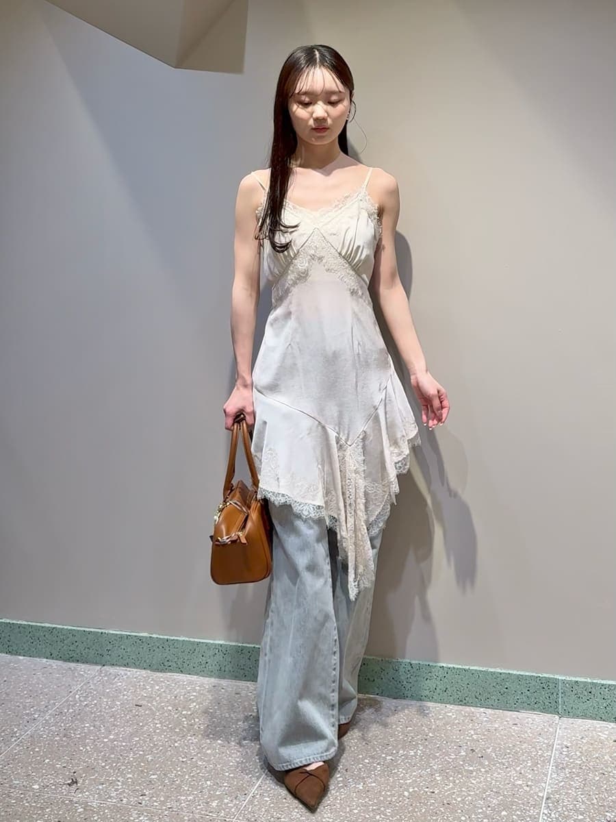 ベージュ系のテーラードジャケット、グレー系のデニムパンツ、ホワイト系のキャミソールを着用したレディースの春コーディネートの3枚目の写真