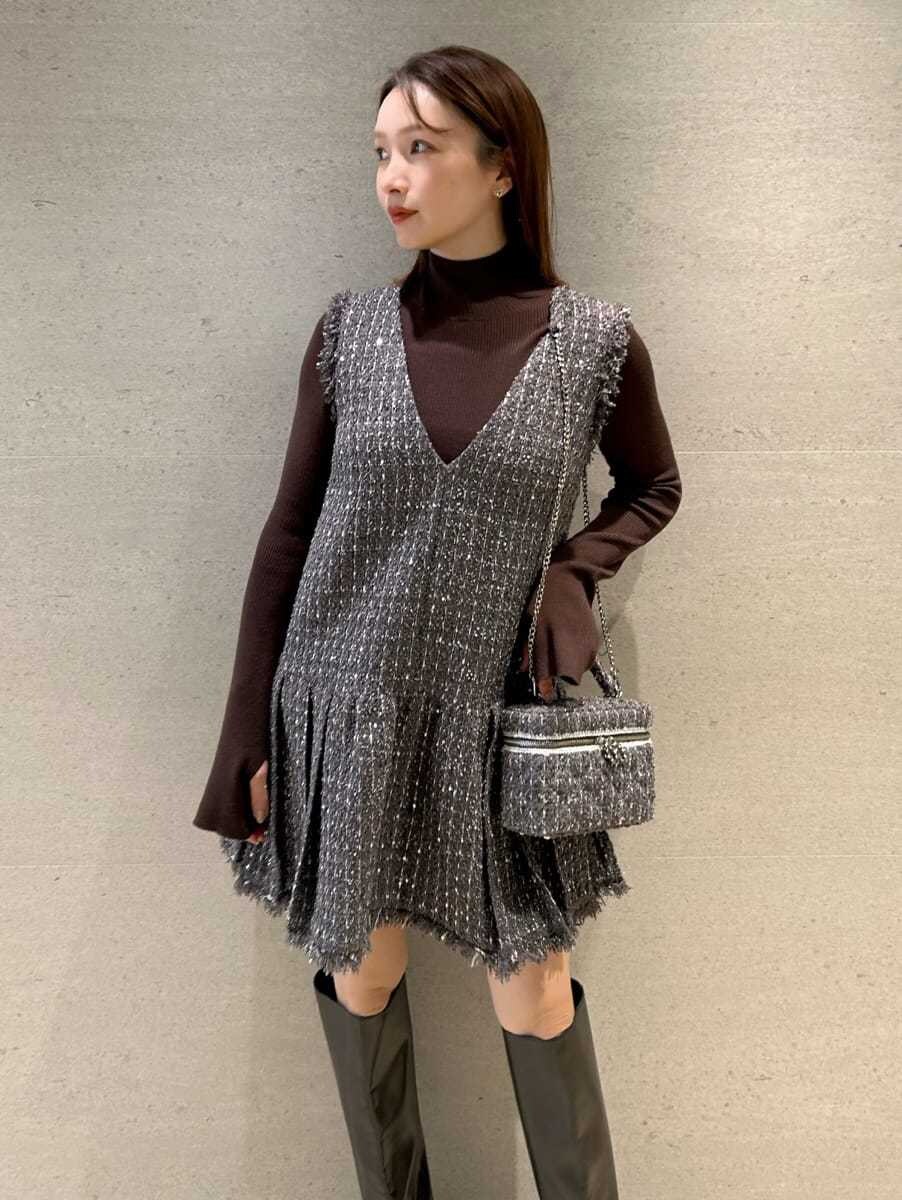 グレー系のワンピース、ブラウン系のニット/セーター、グレー系のハンドバッグを着用したレディースの秋コーディネートの2枚目の写真