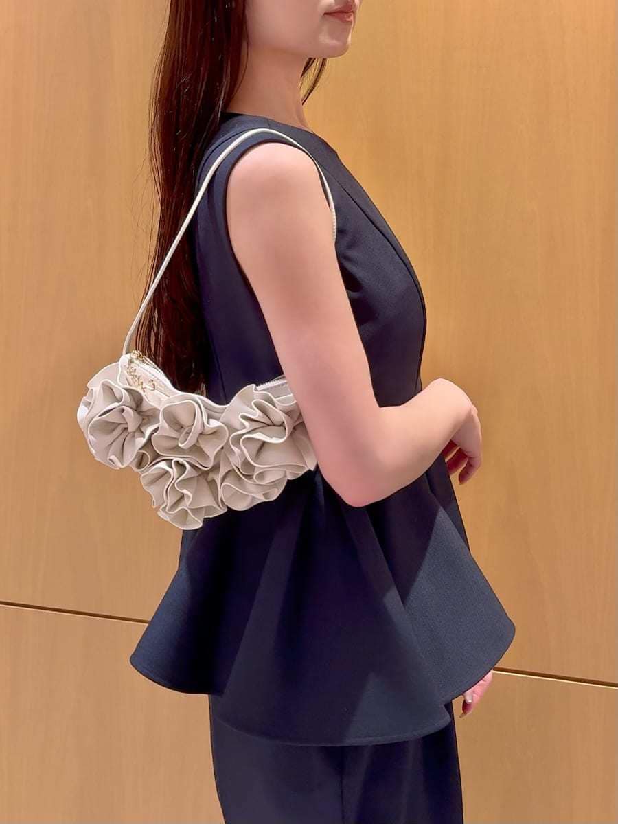 ブルー系のワンピース、ブラック系のパンプス、ホワイト系のハンドバッグを着用したレディースの春コーディネートの5枚目の写真