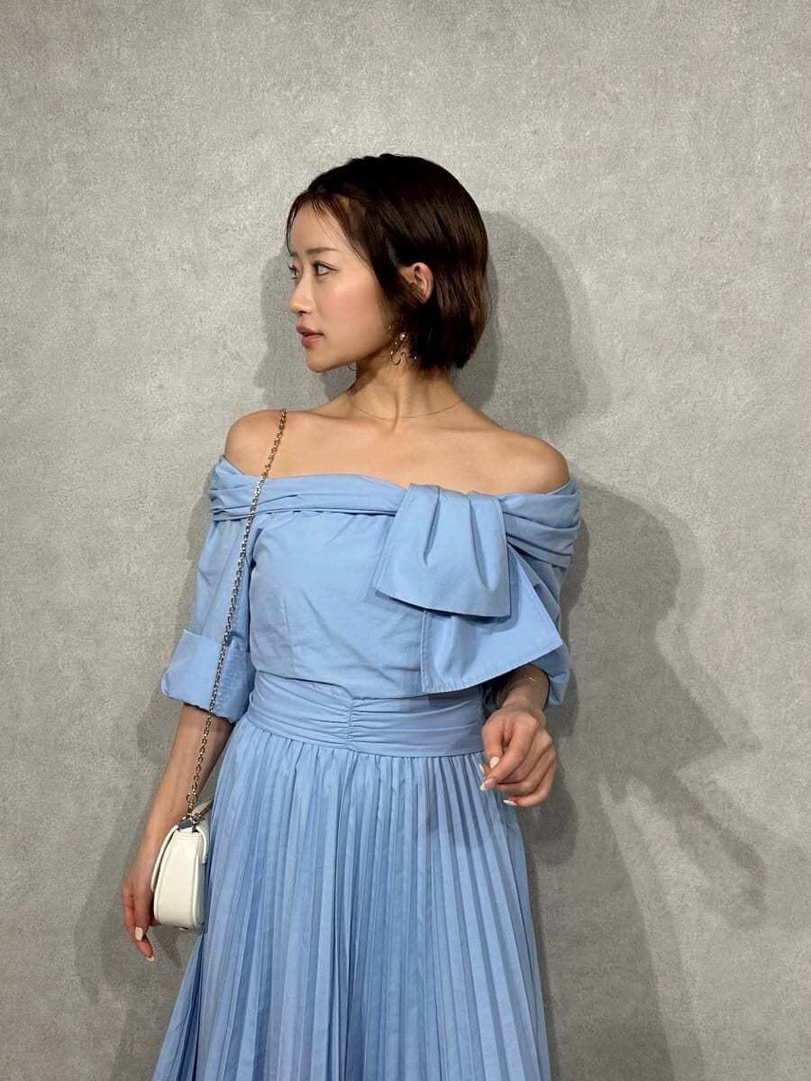 ブルー系のワンピース、その他のパンプス、ホワイト系のショルダーバッグを着用したレディースの冬コーディネートの3枚目の写真