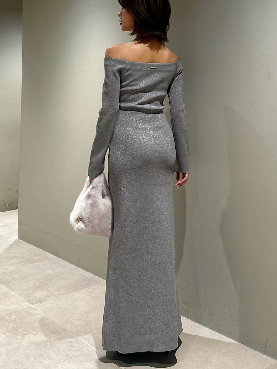 ブラック系のブーツ、シルバー系のワンピース、ホワイト系のハンドバッグを着用したレディースの冬コーディネートの4枚目の写真