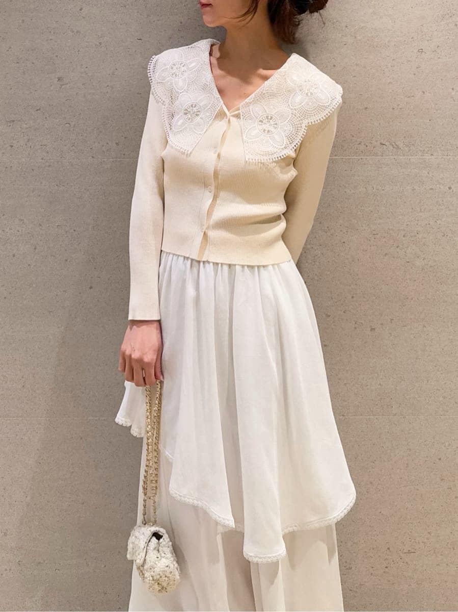 ホワイト系のショルダーバッグ、ホワイト系のスカート、ホワイト系のニット/セーターを着用したレディースの冬コーディネートの3枚目の写真