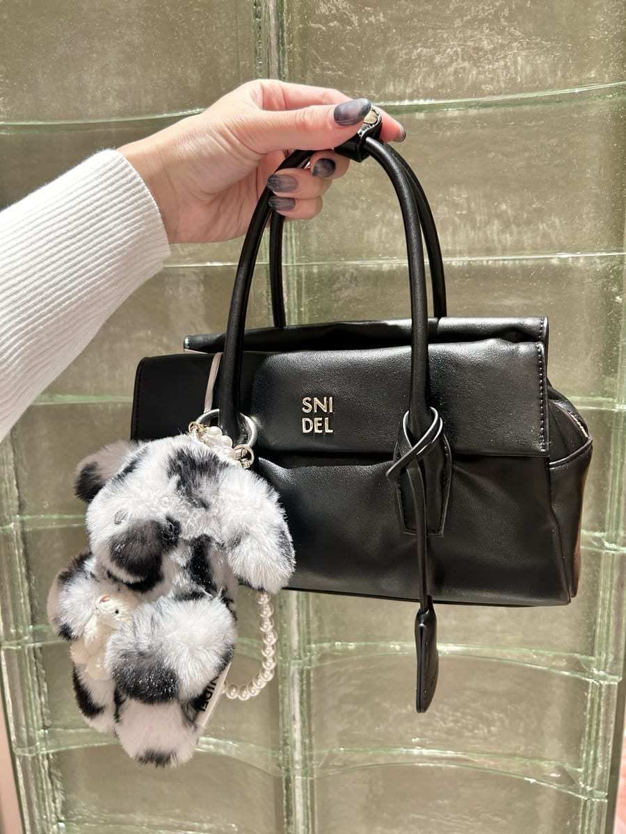 ホワイト系のニット/セーター、グレー系のスカート、ブラック系のボストンバッグを着用したレディースの秋コーディネートの6枚目の写真