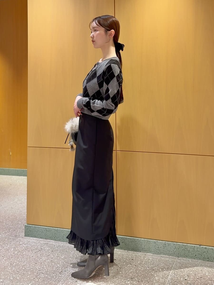 グレー系のブーツ、ブラック系のスカート、グレー系のニット/セーターを着用したレディースの秋コーディネートの2枚目の写真