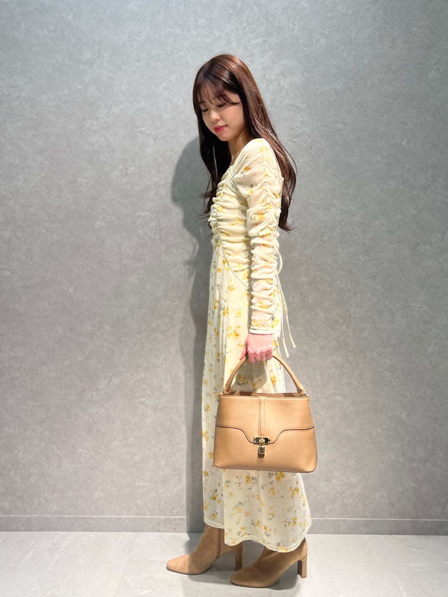 ベージュ系のブーツ、イエロー系のワンピース、イエロー系のハンドバッグを着用したレディースの冬コーディネートの4枚目の写真