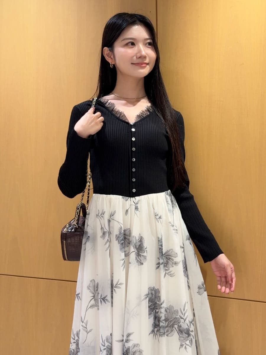 ブラック系のワンピース、ブラック系のパンプス、レッド系のショルダーバッグを着用したレディースの秋コーディネートの4枚目の写真