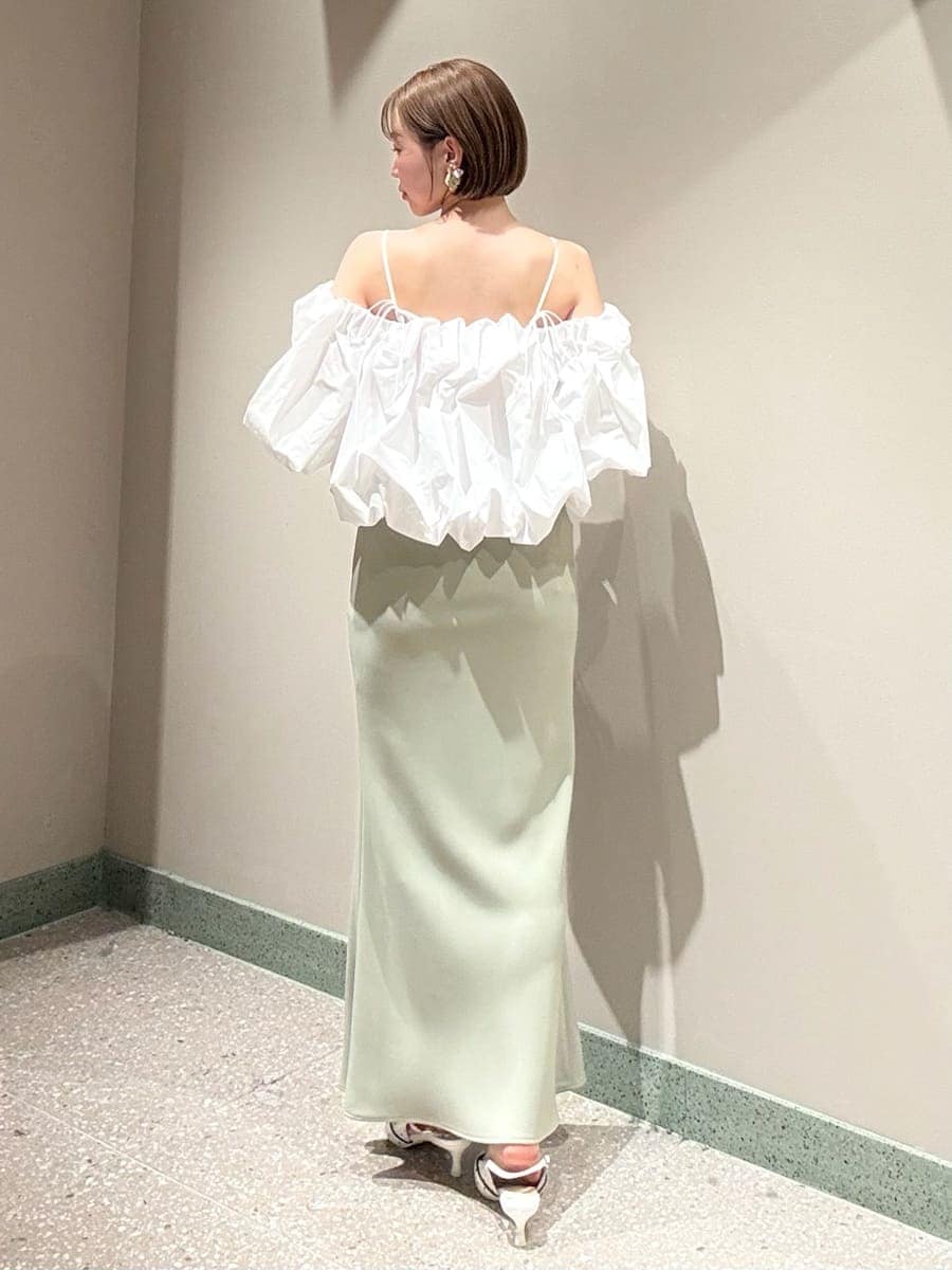 グリーン系のスカート、ホワイト系のシャツ/ブラウス、ホワイト系のハンドバッグを着用したレディースの春コーディネートの6枚目の写真