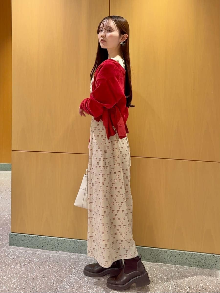 ホワイト系のハンドバッグ、ベージュ系のワンピース、レッド系のカーディガン/ボレロを着用したレディースの冬コーディネートの2枚目の写真