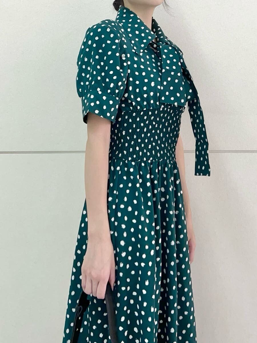 グリーン系のワンピース、ブラック系のトートバッグを着用したレディースの夏コーディネートの6枚目の写真