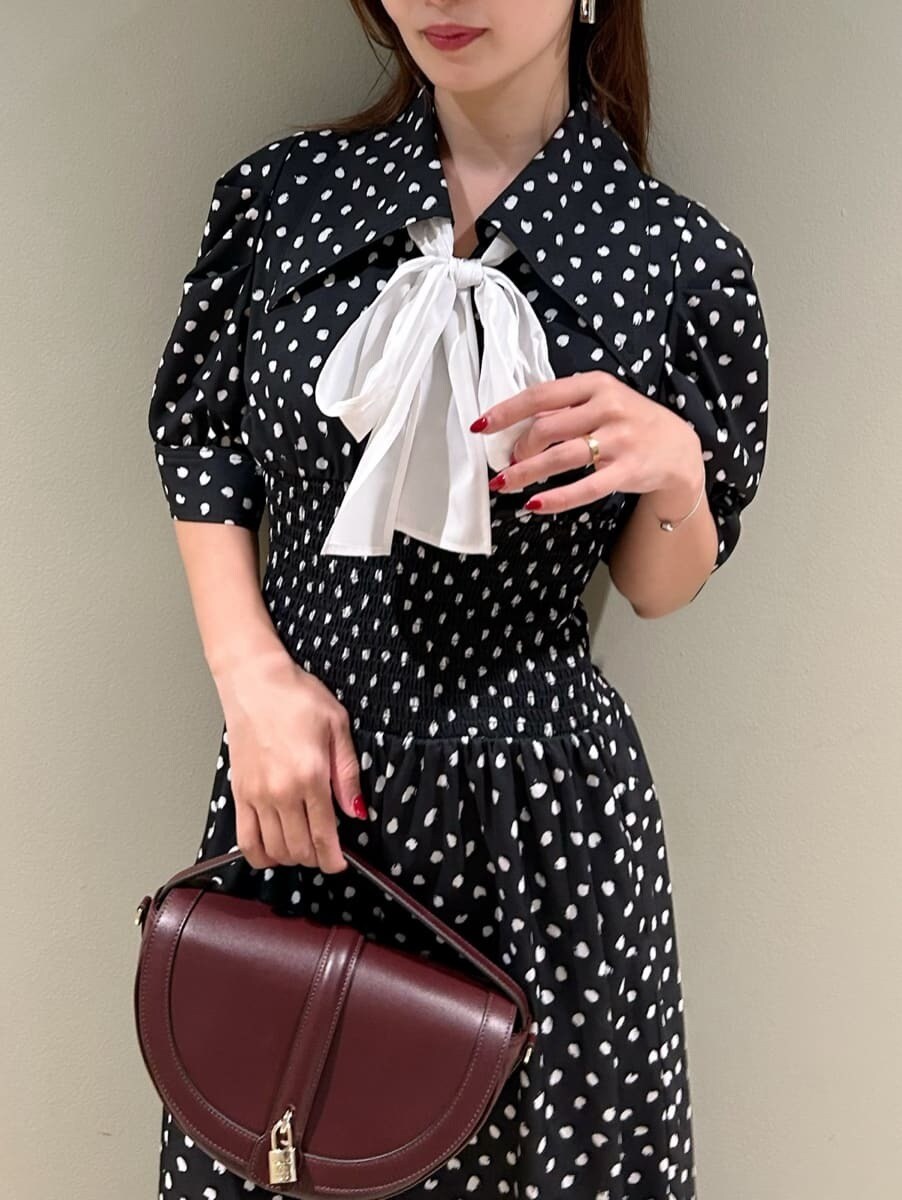 ブラック系のワンピース、ブラウン系のハンドバッグを着用したレディースの秋コーディネートの2枚目の写真