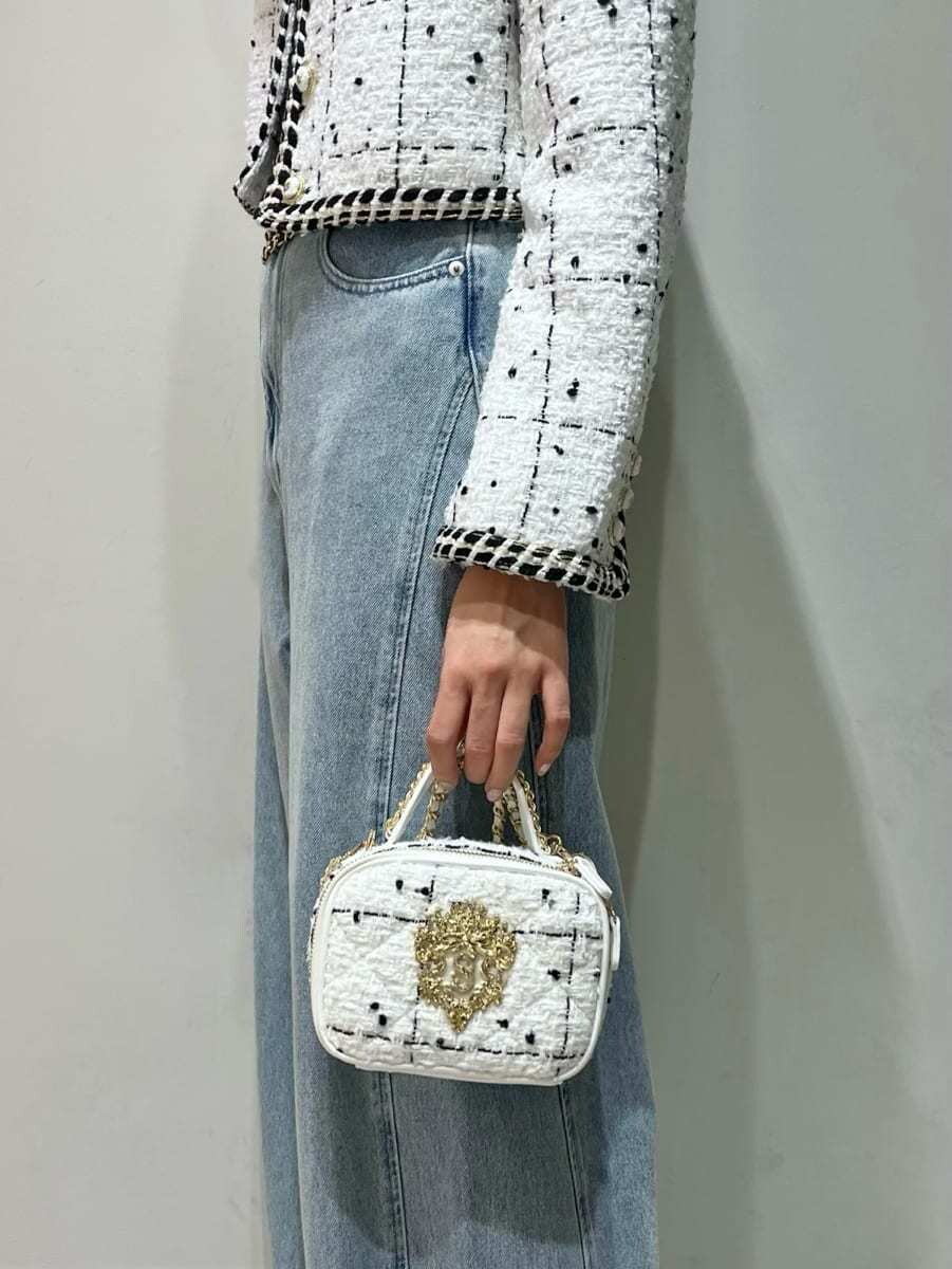 ホワイト系のノーカラージャケット、ブルー系のデニムパンツ、ブラック系のニット/セーターを着用したレディースの秋コーディネートの6枚目の写真